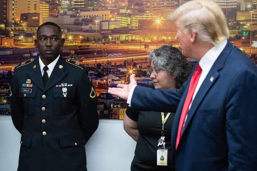 US President Donald Trump (R) gestures to PFC Glendon Oakley (L), who saved several lives...