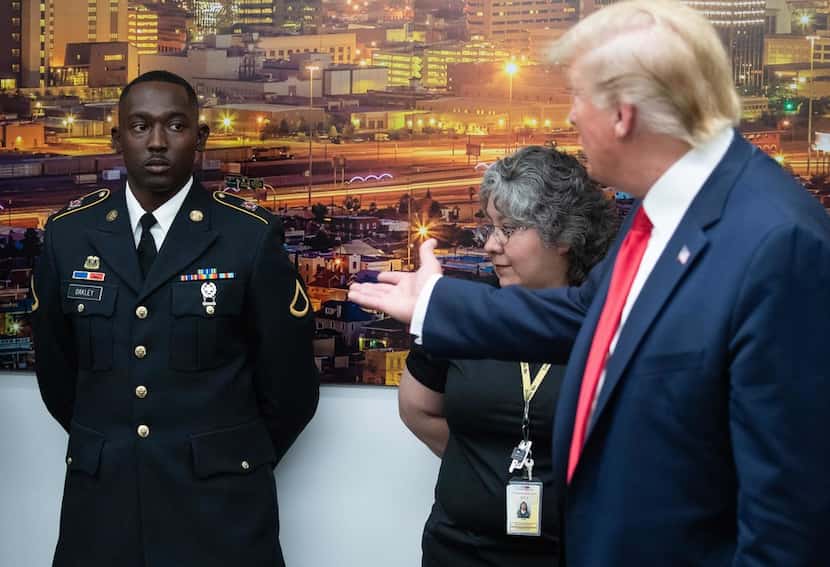 US President Donald Trump (R) gestures to PFC Glendon Oakley (L), who saved several lives...