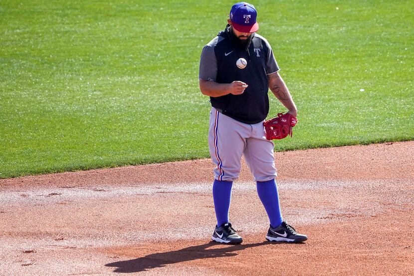 Texas Rangers infielder Rougned Odor tosses a ball while taking grounders at third base...