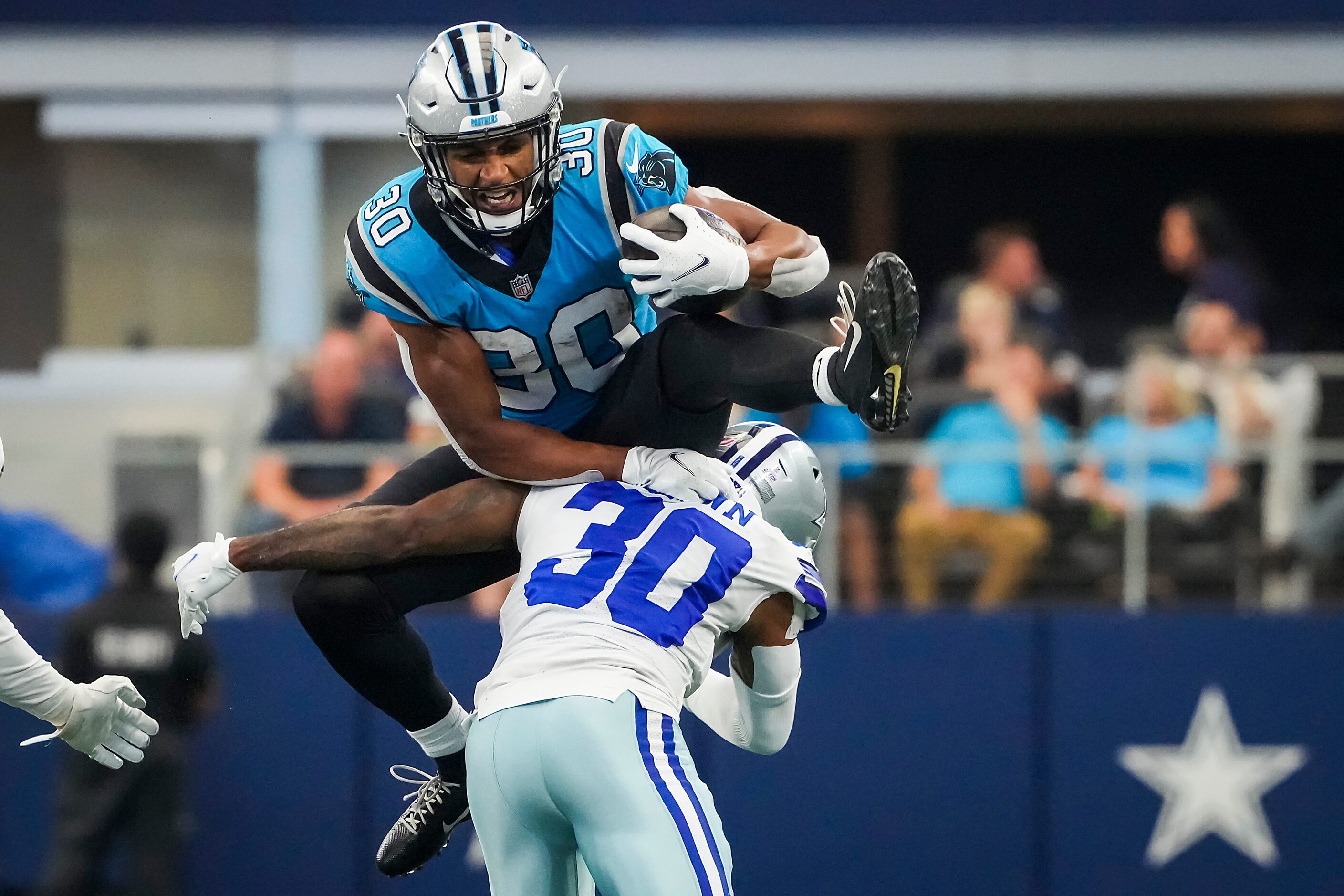 Carolina Panthers running back Chuba Hubbard  tries to hurdle Dallas Cowboys cornerback...