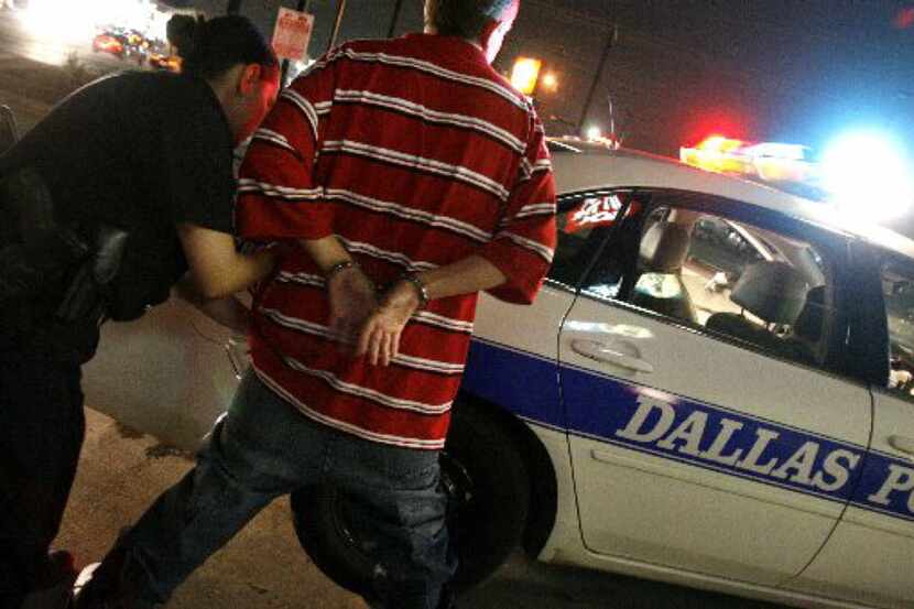 A Dallas police officer searches a juvenile who violated curfew.