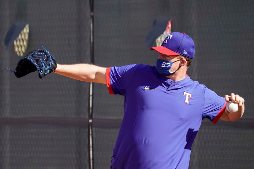 Texas Rangers pitcher Wes Benjamin plays catch during a spring training workout at the...