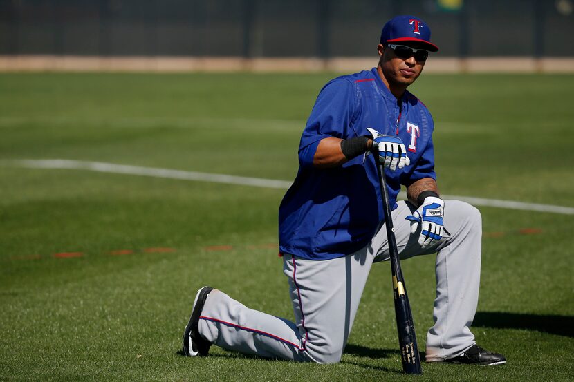 Texas Rangers outfielder Leonys Martin takes a knee in between working on his bunting during...