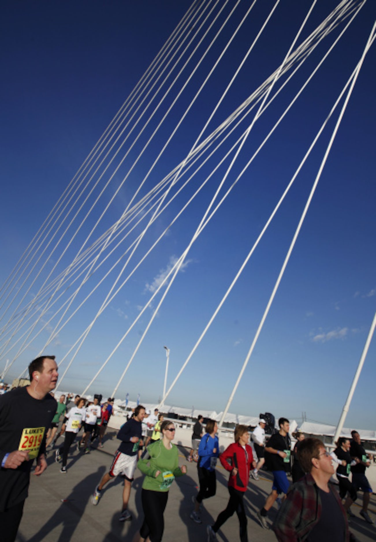 Participants run over the Margaret Hunt Hill Bridge in Dallas, TX during Trinity Sprint...