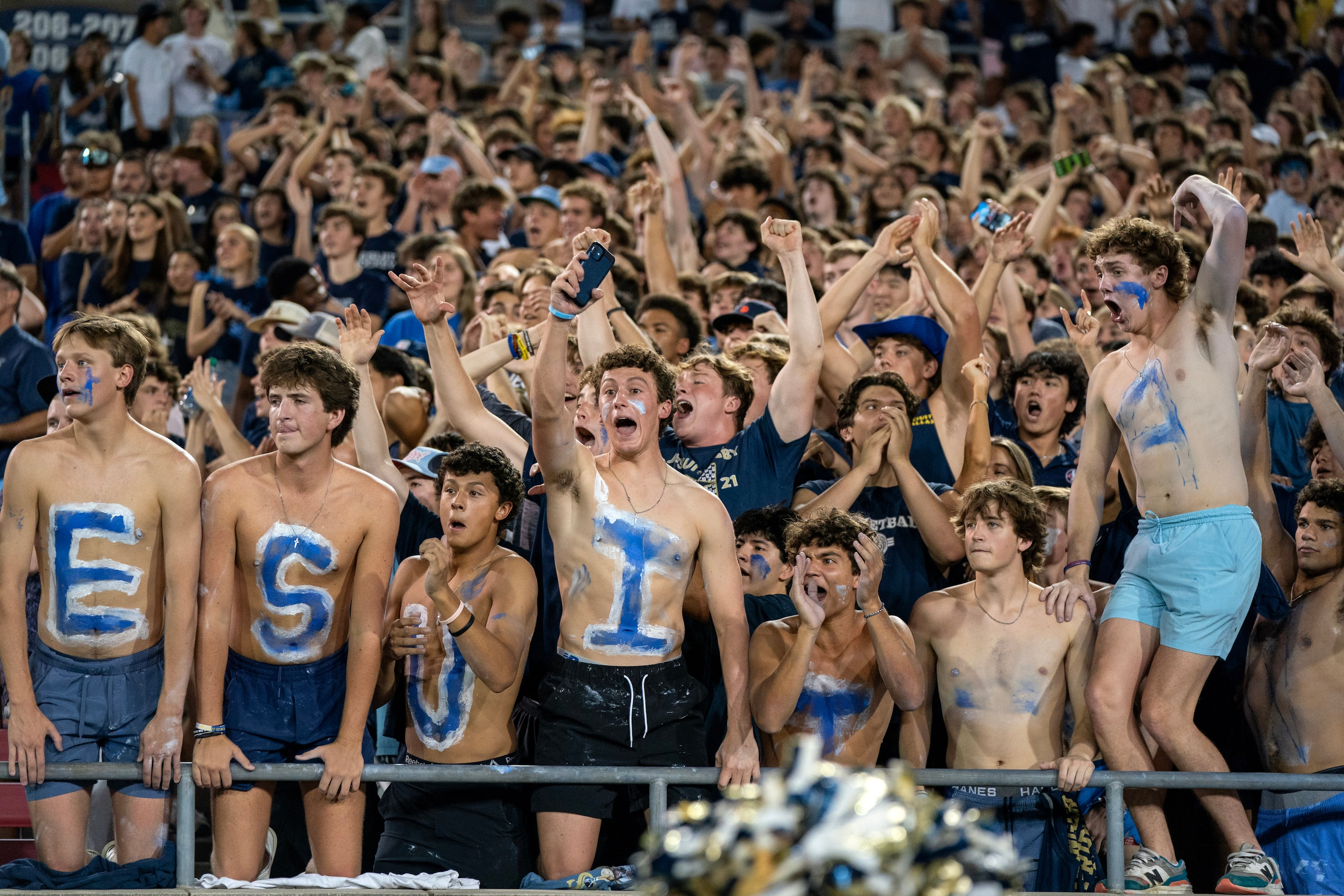 The Jesuit student section cheers during the first half of a high school football game...