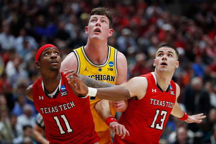 ANAHEIM, CALIFORNIA - MARCH 28: Jon Teske #15 of the Michigan Wolverines fights for position...
