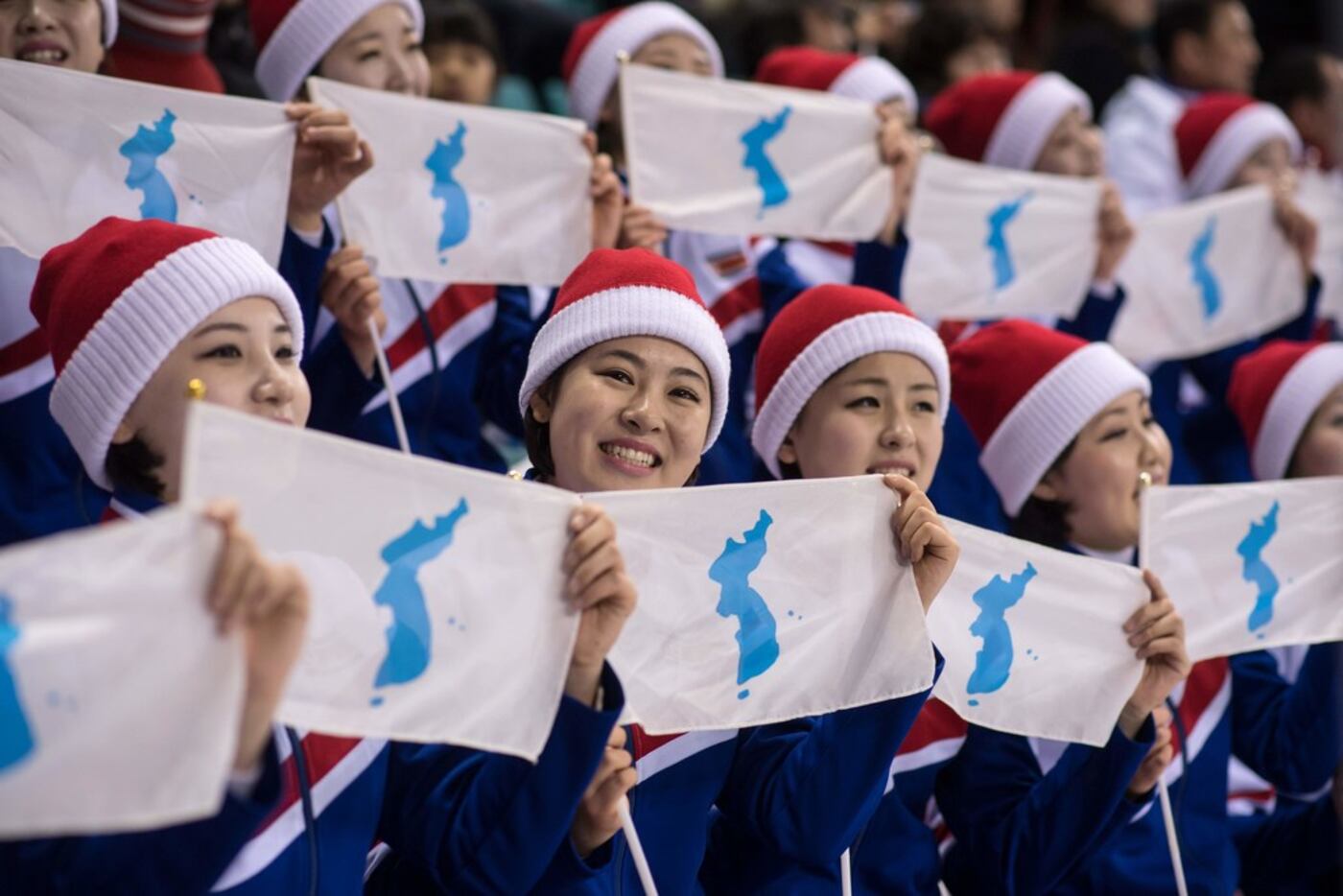 North Korean cheerleaders hold Unified Korea flags during the women's preliminary round ice...
