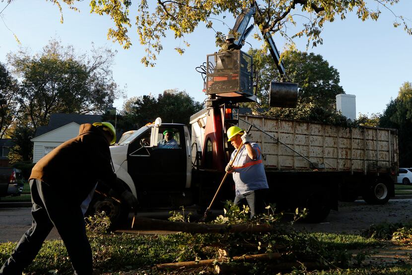 Dallas Sanitation Services employees Gustave Nealy, left, Darrell Wortham, in cab, Atmos...