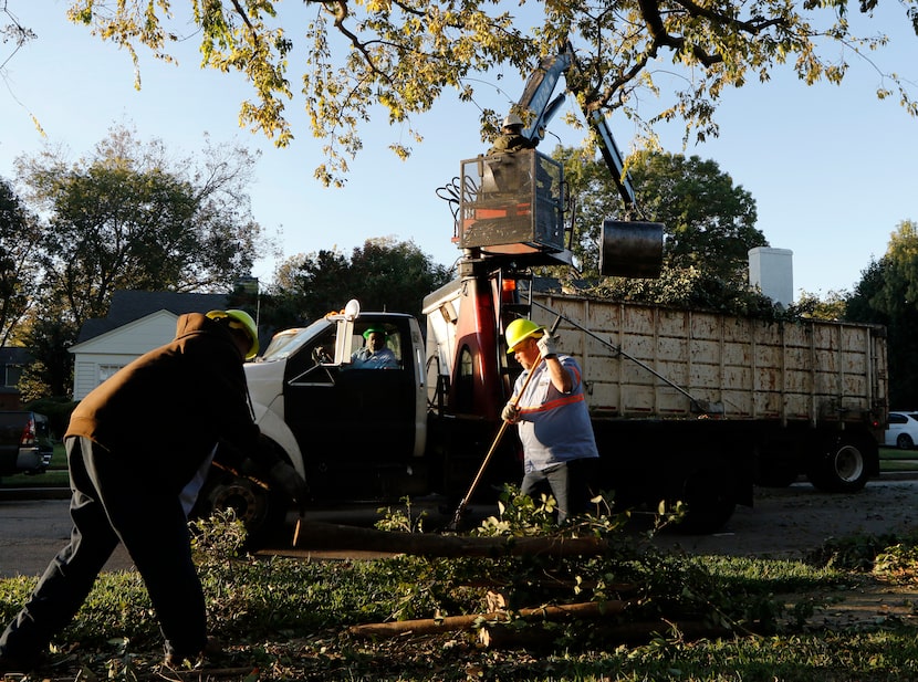 Dallas Sanitation Services employees Gustave Nealy, left, Darrell Wortham, in cab, Atmos...