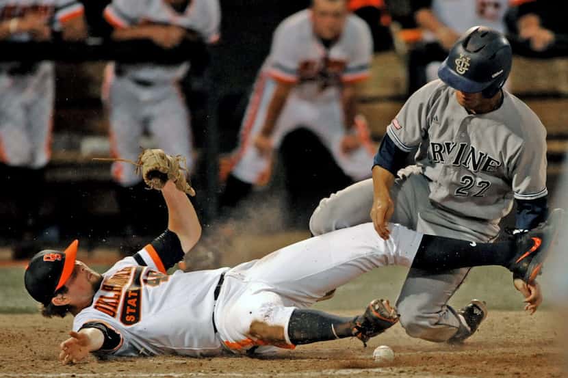 UC Irvine infielder Chris Rabago, right collides with Oklahoma State pitcher Jon Perrin...