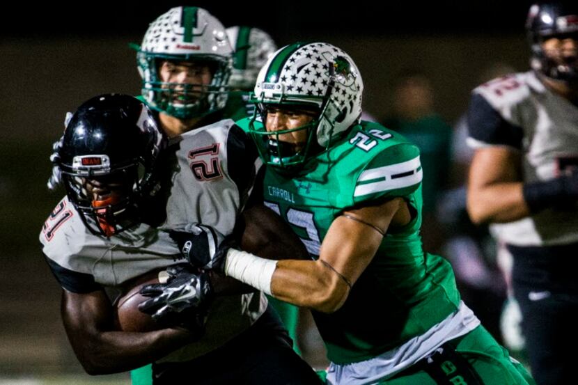 Euless Trinity running back Courage Keihn (21) is tackled by Southlake defensive back...