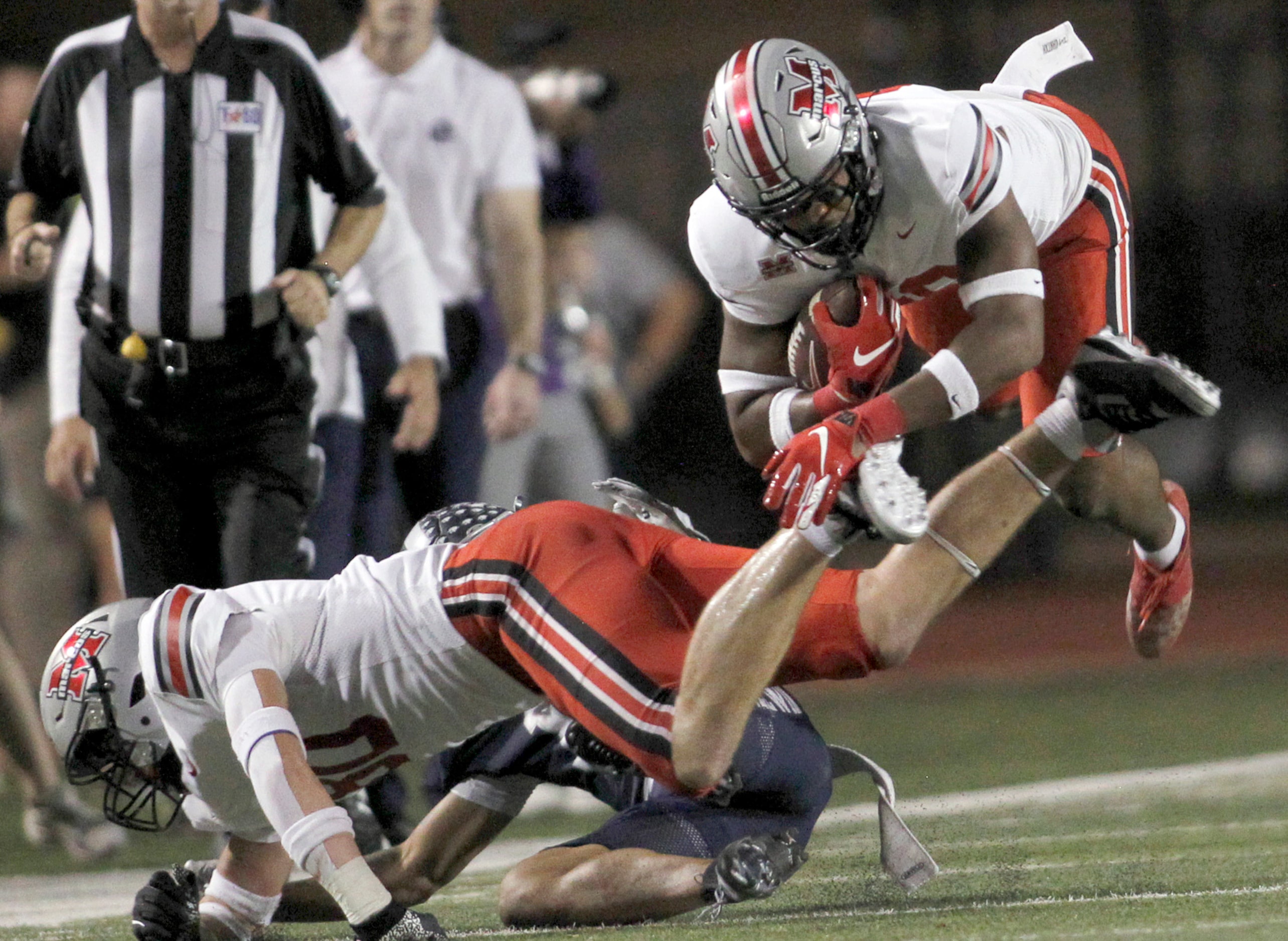 Flower Mound Marcus running back Arinze Cos-Okpalla (29) leaps over a couple of players for...