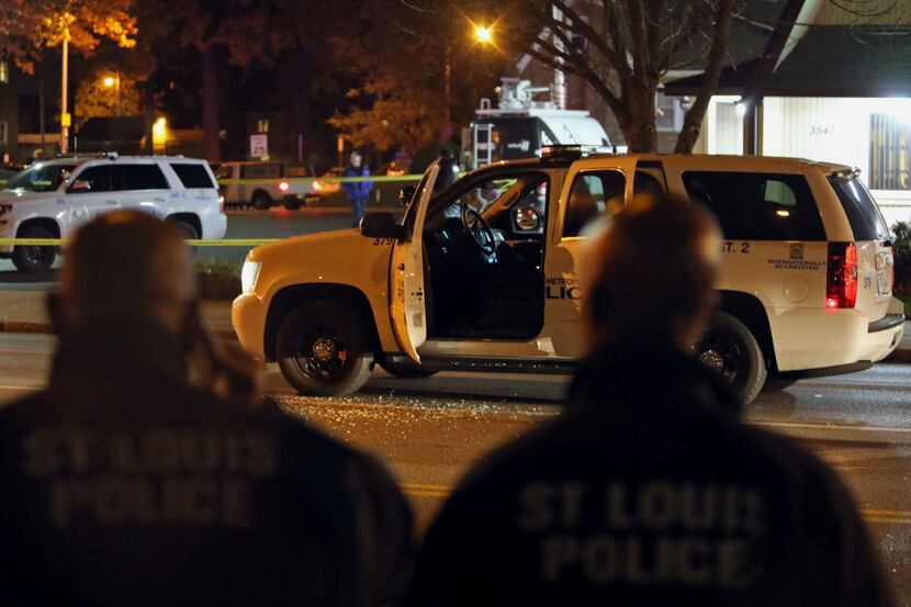 Police investigate a scene after a St. Louis police officer was shot in what the police...