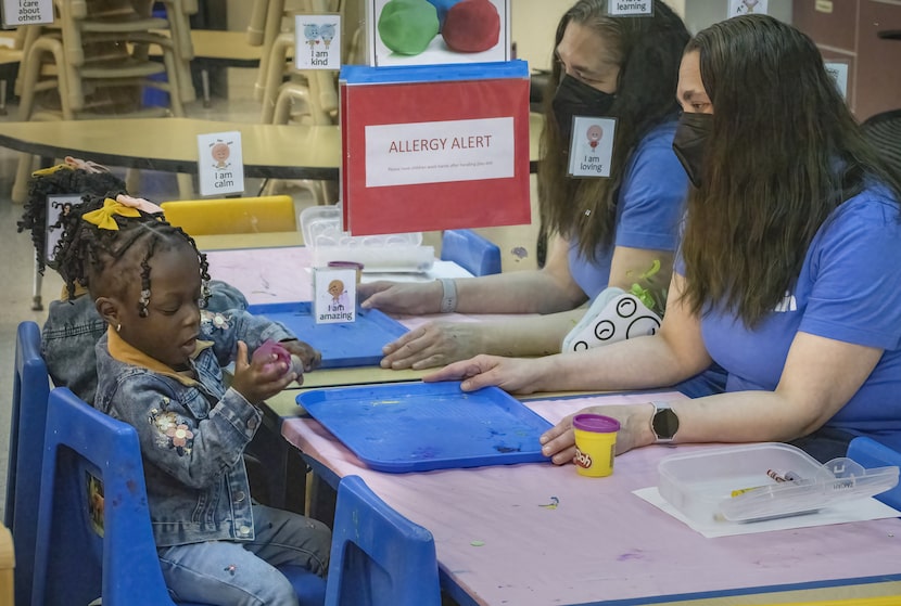 Jenna Carodiskey-Wiebe, assistant teacher with ECEAP, right, watches as two-year-old Zakiah...