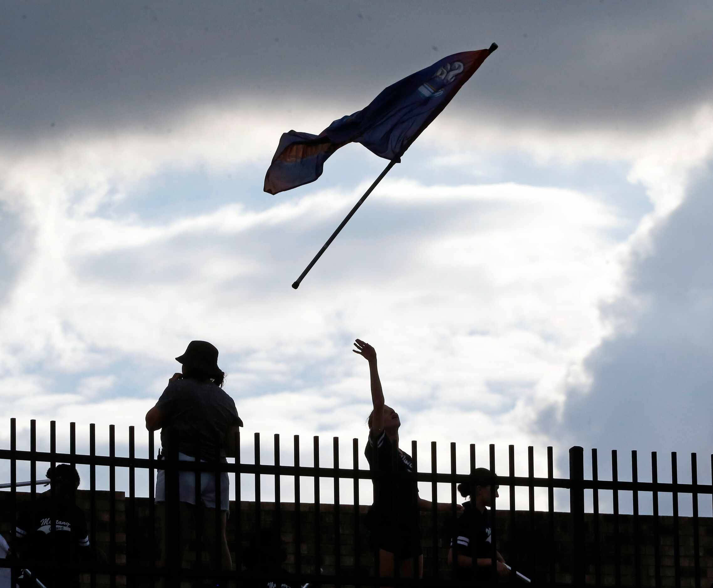 A Sachse flag team member throws her flag high into the air during a practice prior to the...