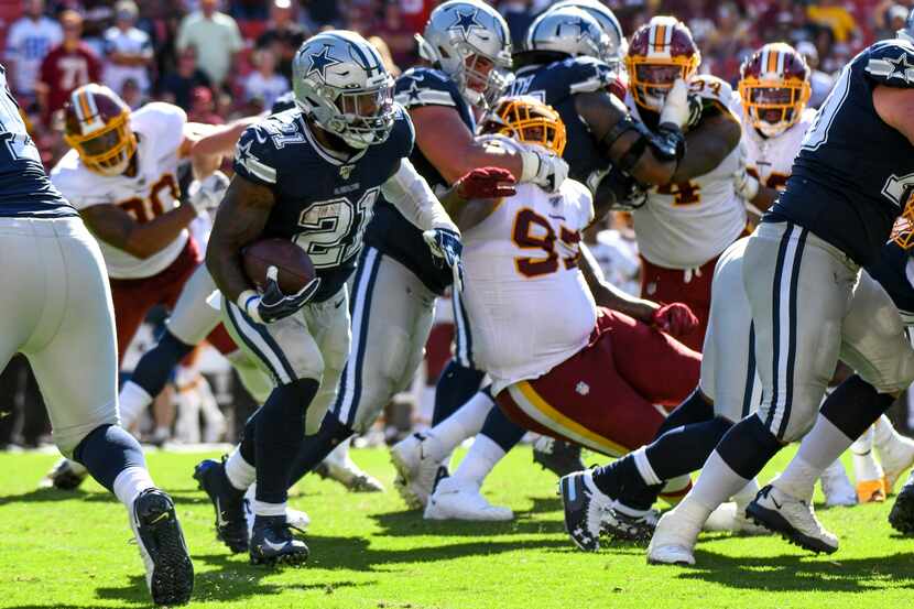 El corredor de los Dallas Cowboys, Ezekiel Elliott (21), acarrea el balón contra los...