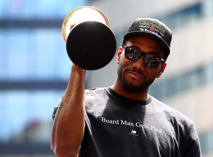Kawhi Leonard of the Toronto Raptors holds the MVP trophy during the team's victory parade...