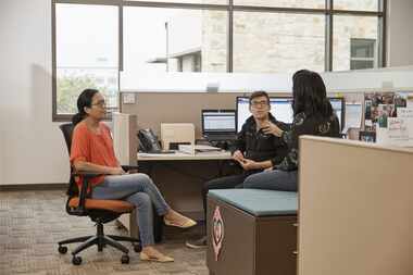 Workers collaborate at their desks at Tyler Technologies.