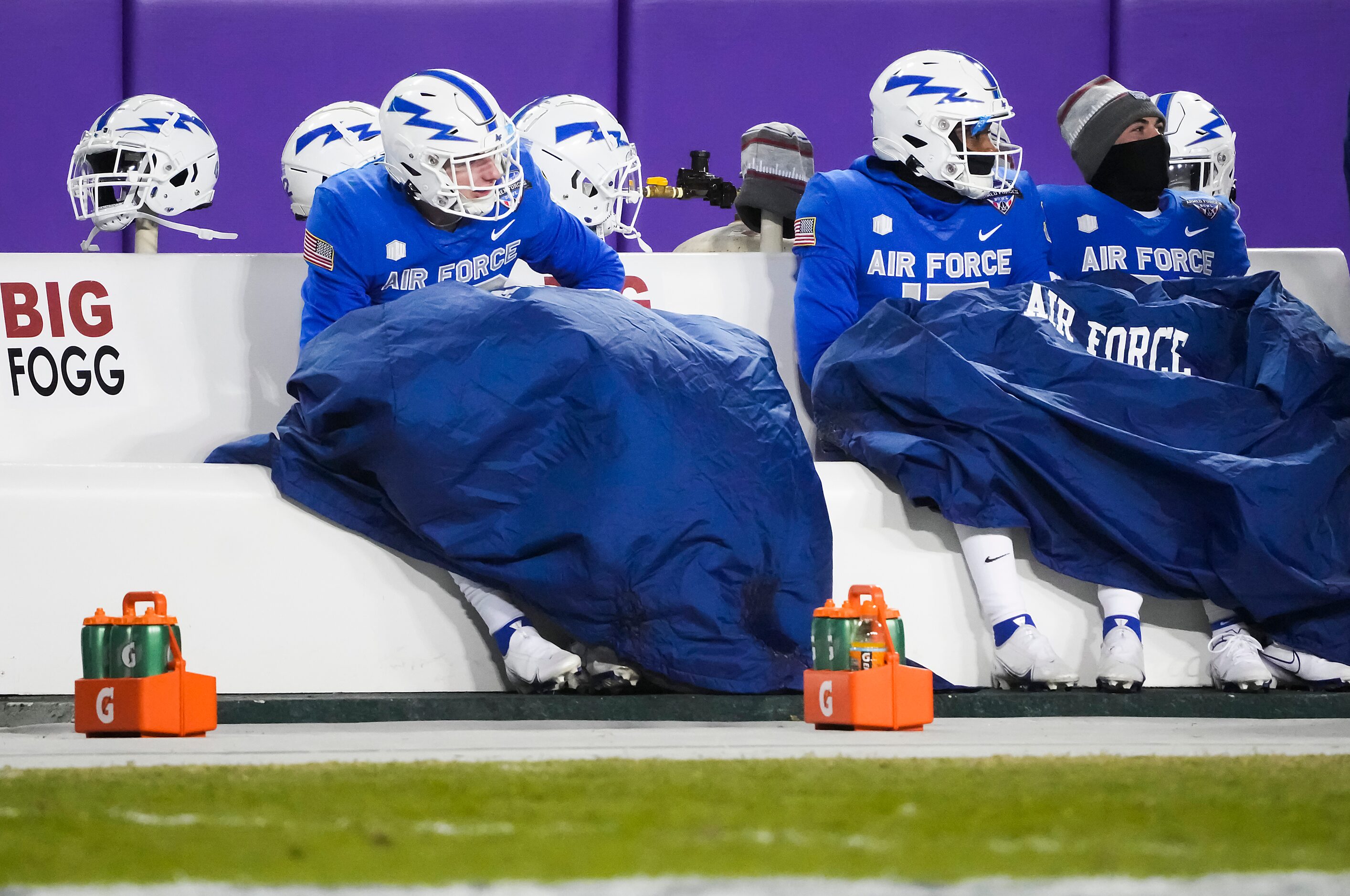 Air Force player try to stay warm on the bench during the second half of the Armed Forces...