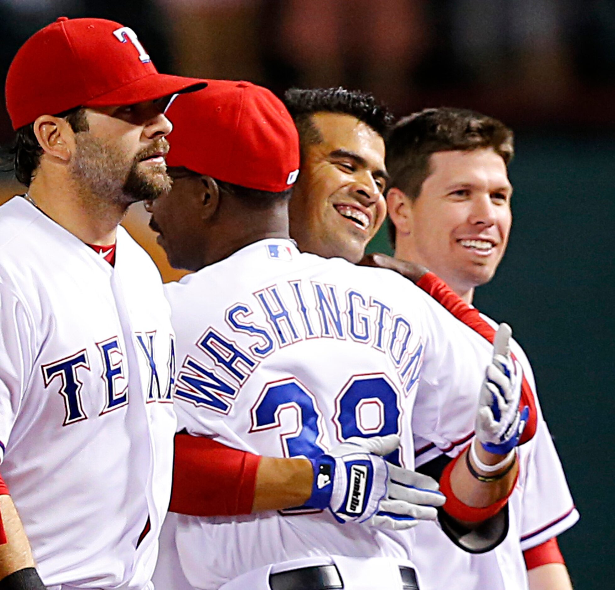 Texas Rangers Robinson Chirinos (second from right) receives a hug from manager Ron...