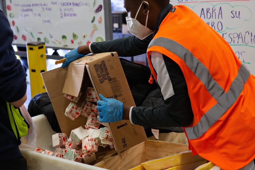 Rae Hughes, an intern with Crossroads Community Services, refills a crate of strawberry milk...