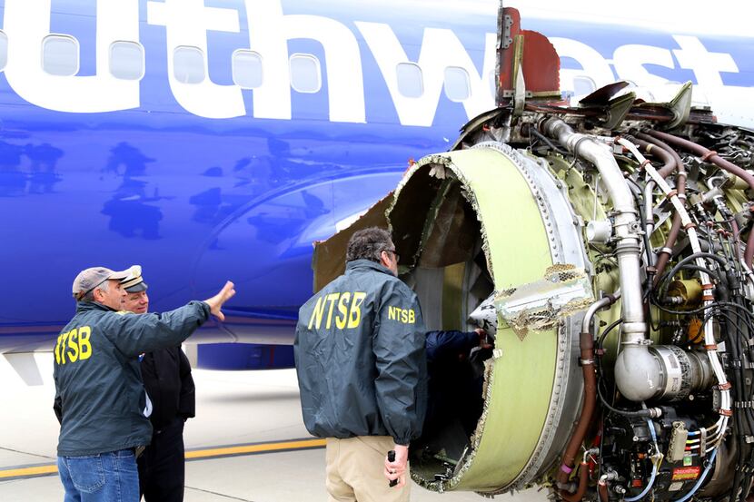NTSB investigators examine damage to the CFM International 56-7B turbofan engine on...