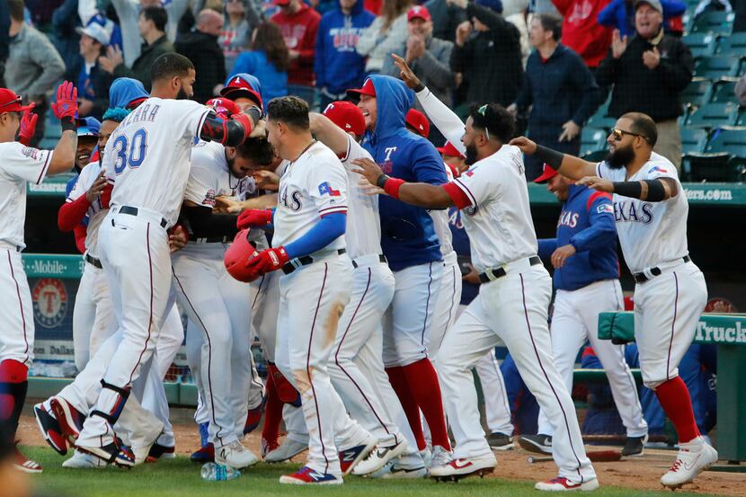 Texas Rangers Joey Gallo is mobbed by his teammates after scoring the game winning run...