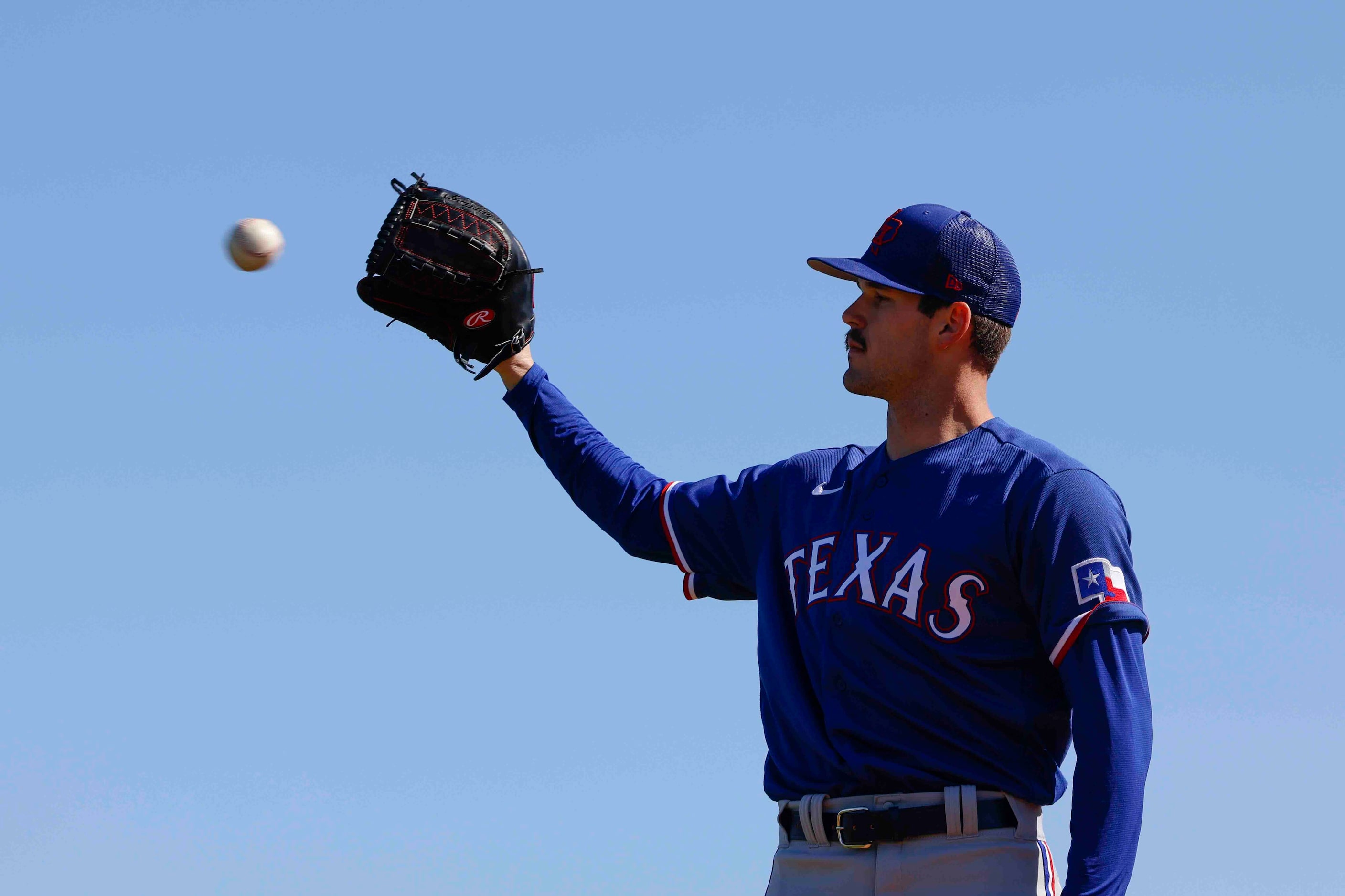 Texas Rangers left handed pitcher Cole Ragans catches a ball as he practices pitching during...