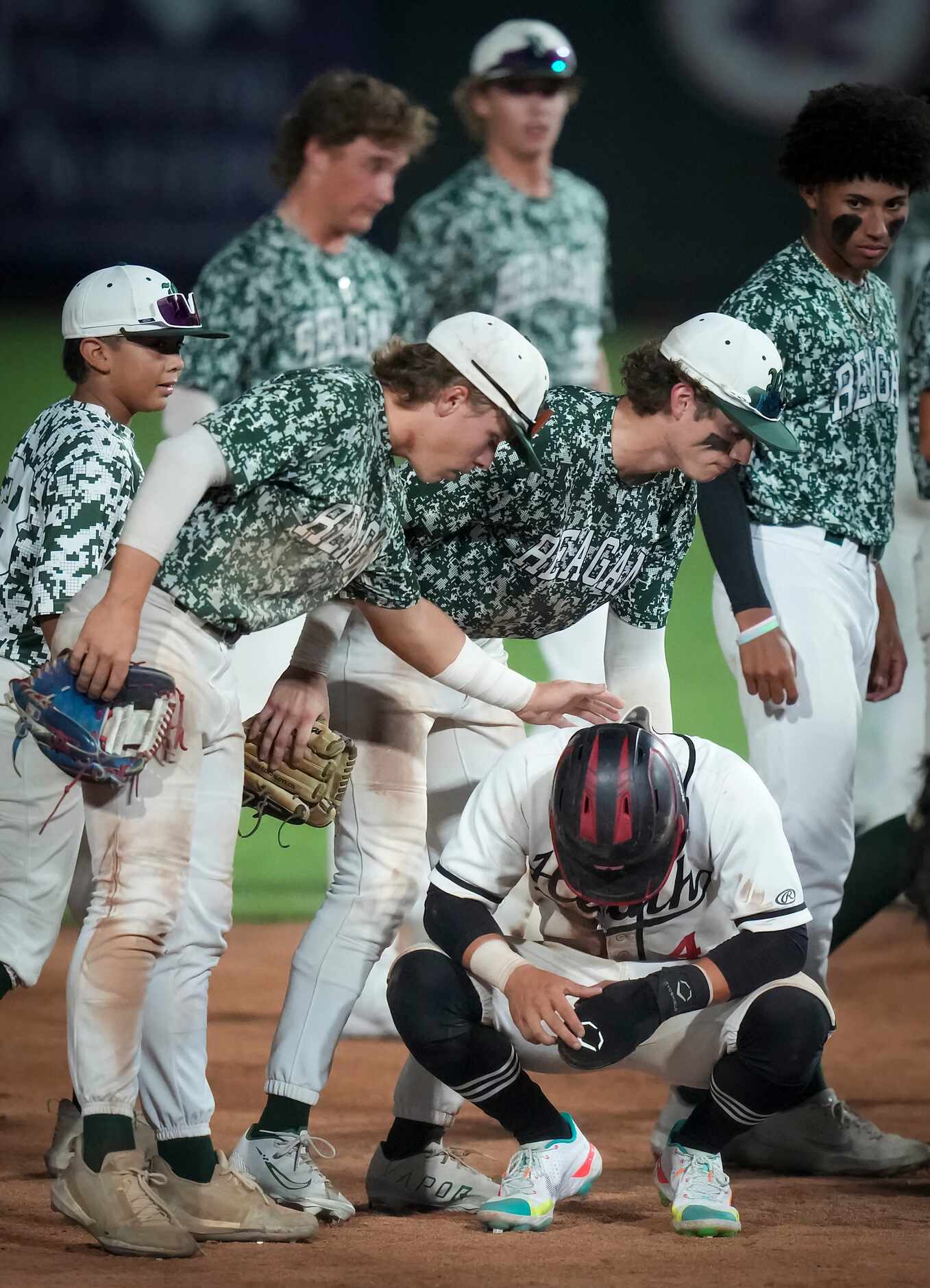 Rockall-Heath shortstop Jett Williams is consoled by San Antonio Reagan players Alex Stowers...