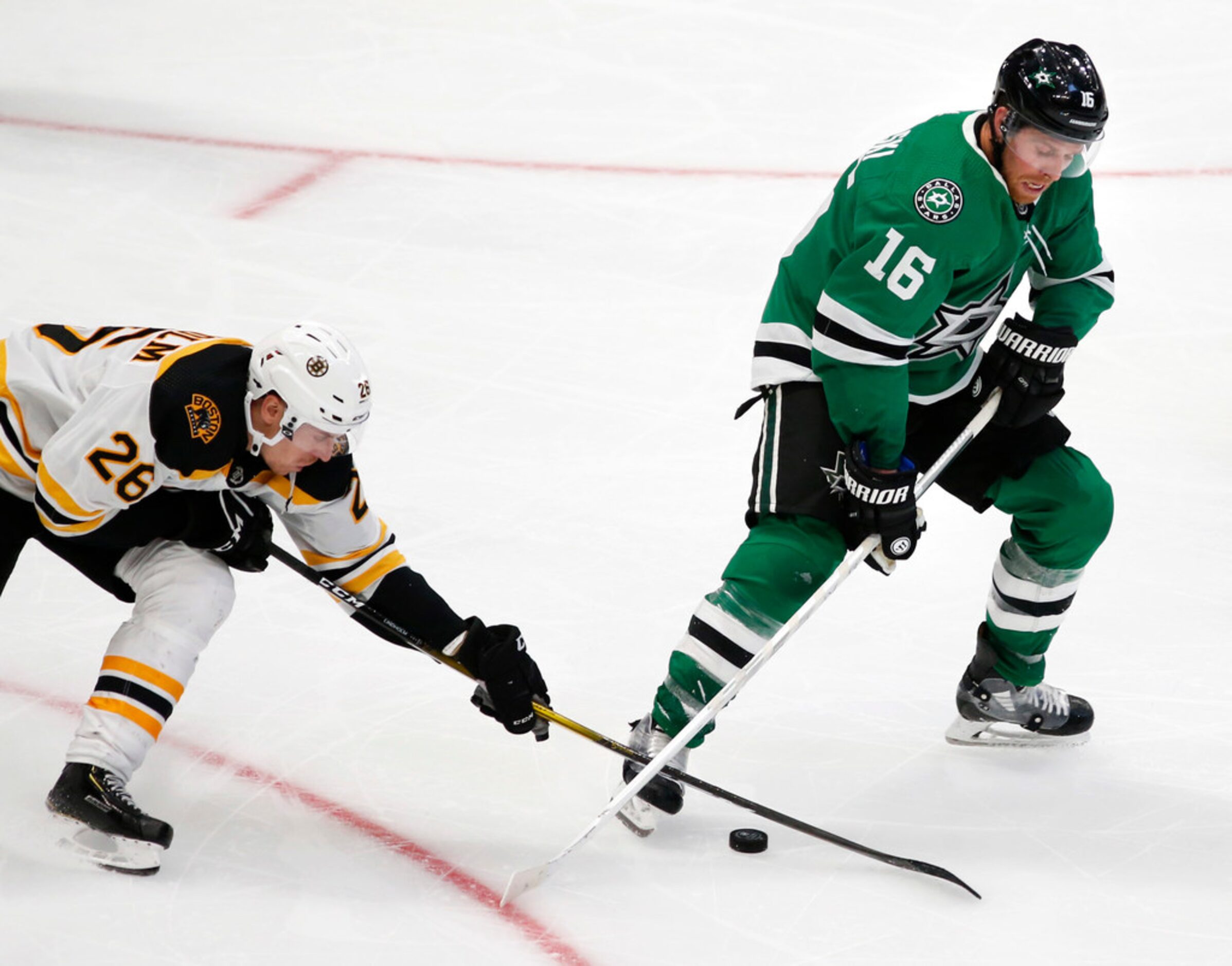 Dallas Stars center Joe Pavelski (16) and Boston Bruins center Par Lindholm (26) go after...