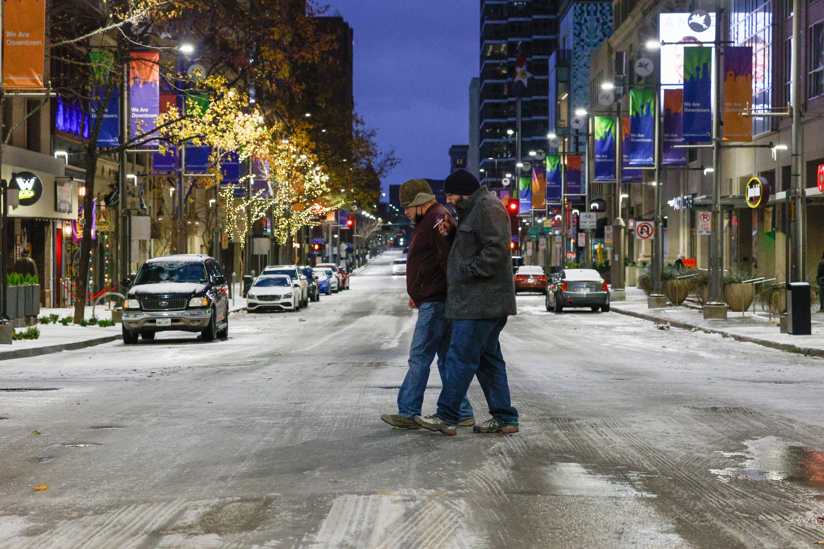 Shane Yeager (left) and Owen Powell cross Main Street at Akard Stree in downtown Dallas on...