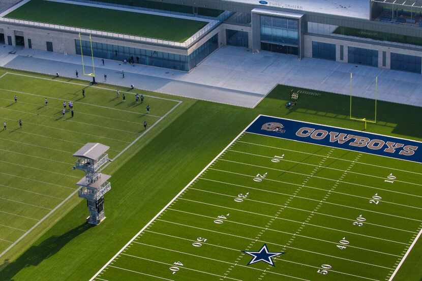 Dallas Cowboys players practice on the practice field at The Star, the world headquarters...