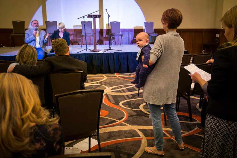 Emily Franklin of Anna holds her son Caleb as she asks a question of environmental activist...