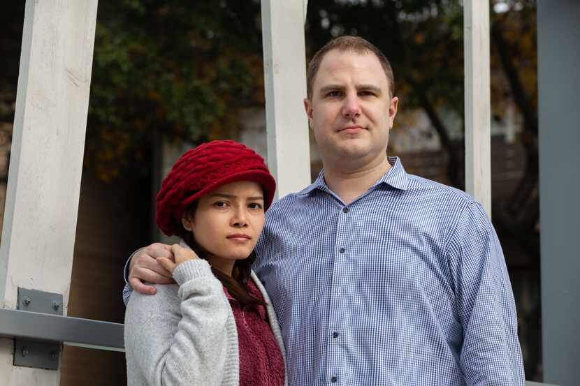 Spouses Aaron Jones (right) and Trinh Nguyen pose for a portrait at their apartment complex...
