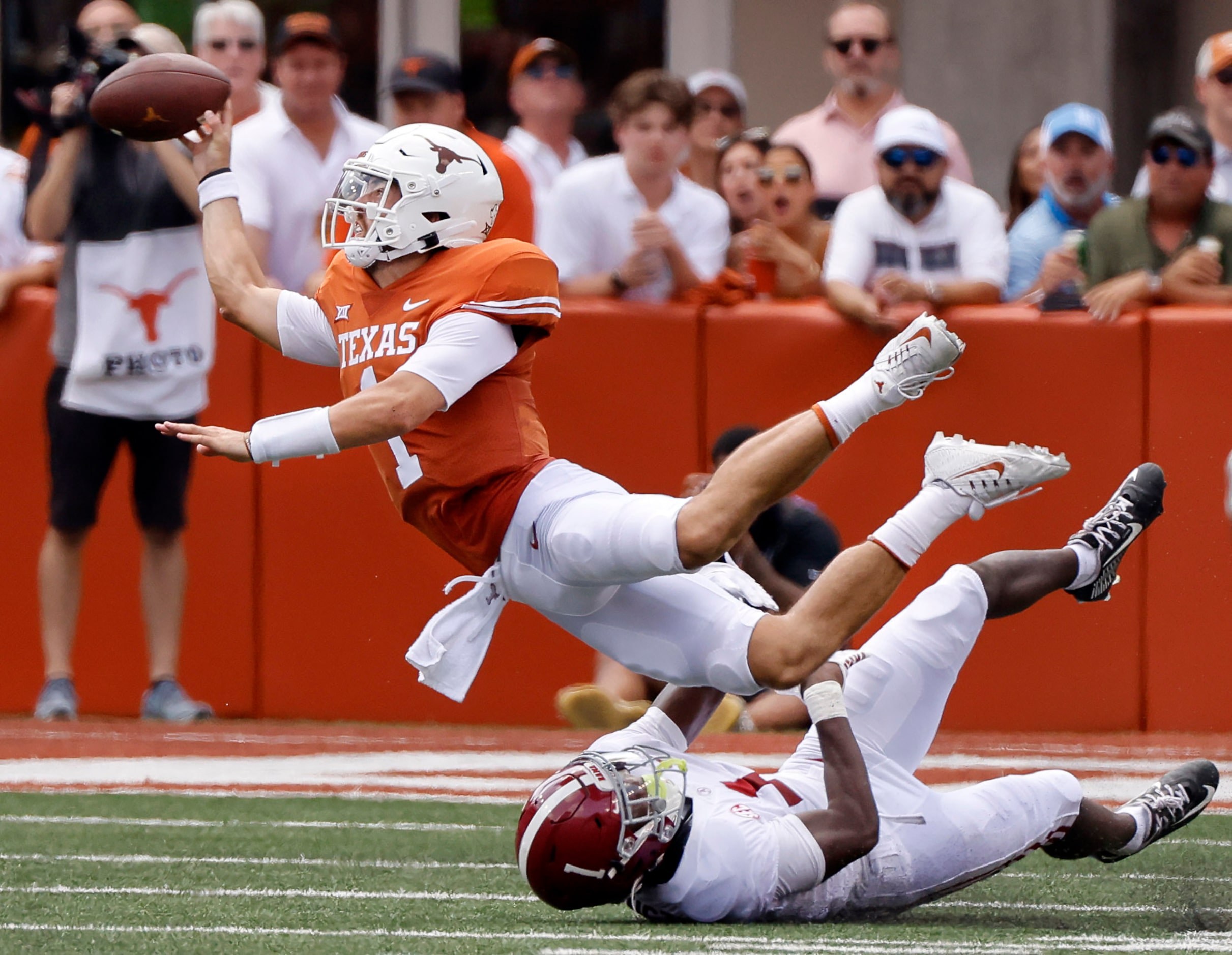 Texas Longhorns quarterback Hudson Card (1) throws the ball away to avoid the sack by...