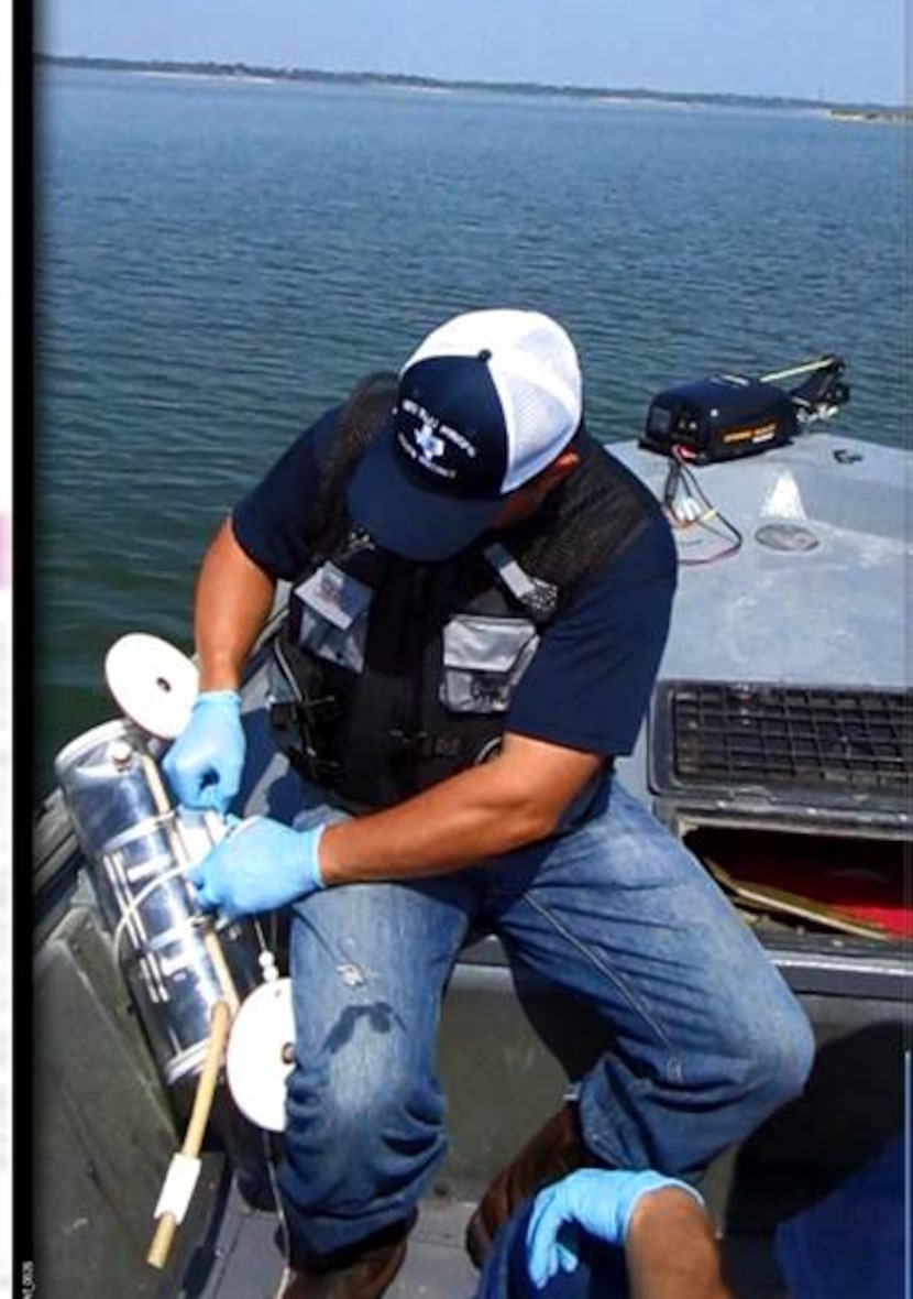 Bo Spears, a district environmental technician, collects water samples for tested for...