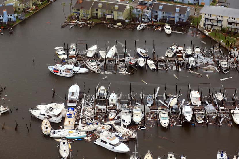 This aerial photo shows damaged boats along a dock in the wake of Hurricane Harvey, Monday,...