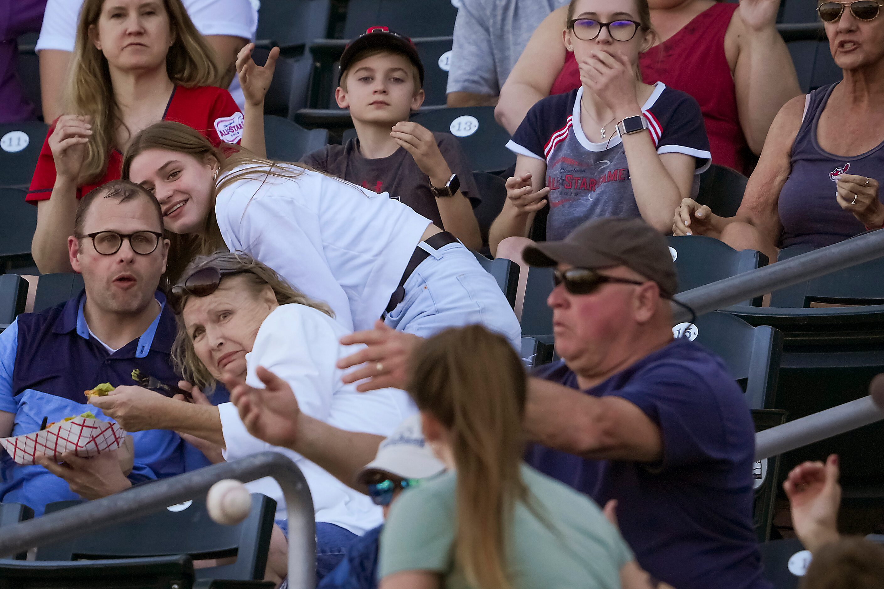 Fans in the stands scramble as a foul ball off the bat of Texas Rangers outfielder Steele...