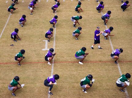 Stephen F. Austin Lumberjacks stretch as coach Colby Carthel leads them during practice in...