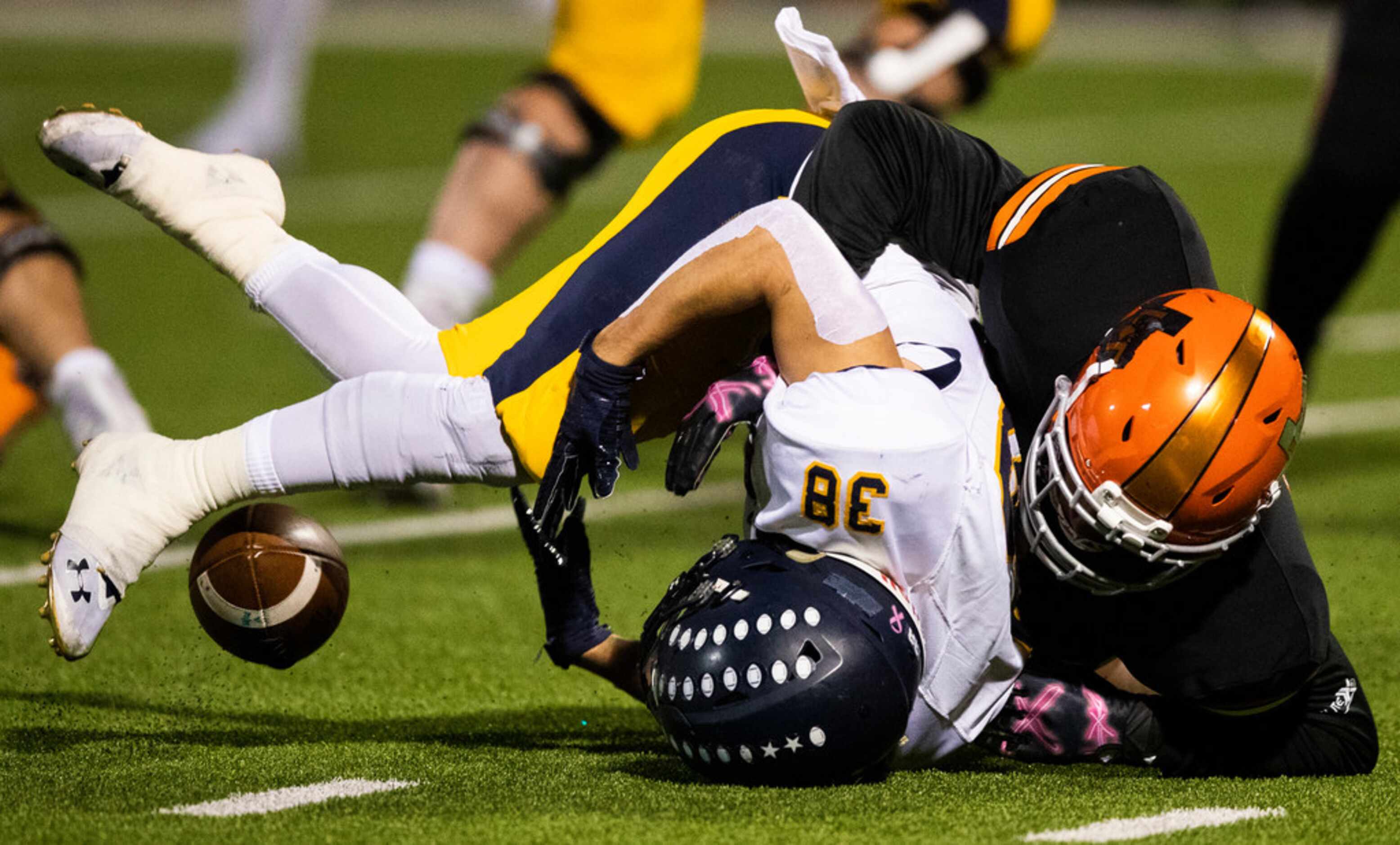 Highland Park running back Hunter Heath (38) fumbles the ball while being tackled by a...