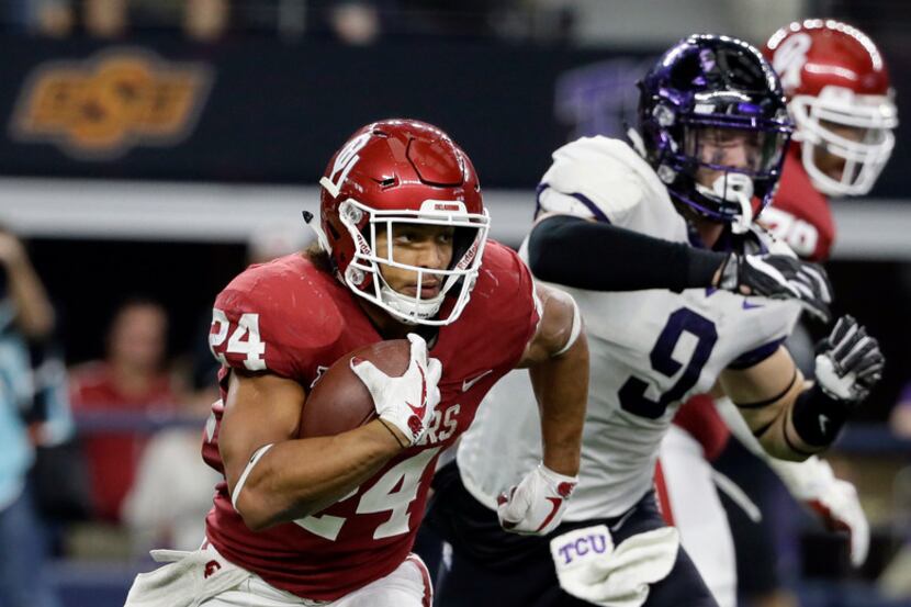 Oklahoma running back Rodney Anderson (24) evades pressure from TCU defensive end Mat Boesen...