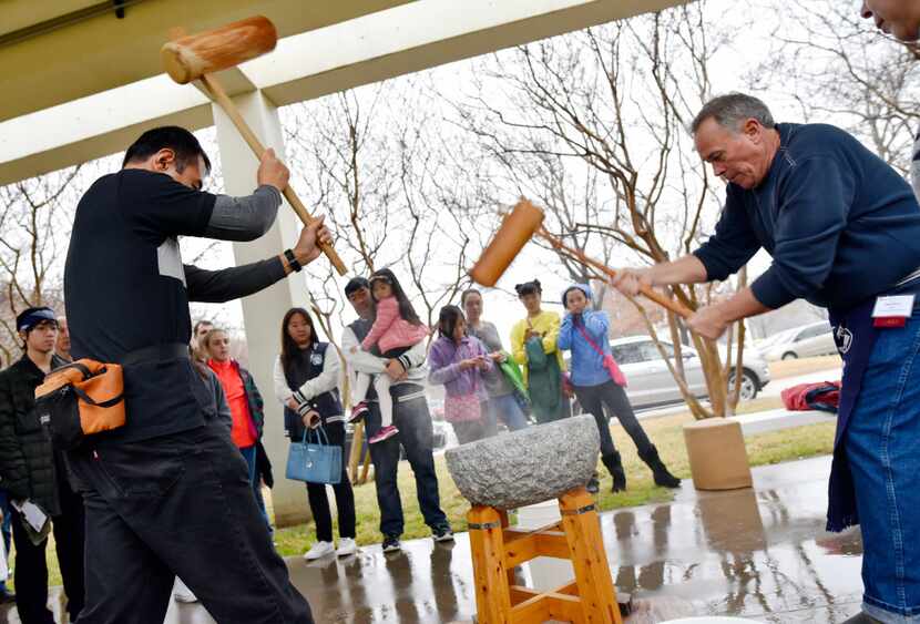 Naoki Hariyama, 46, left, and Mark Berry, 56, right, perform a rice pounding called...