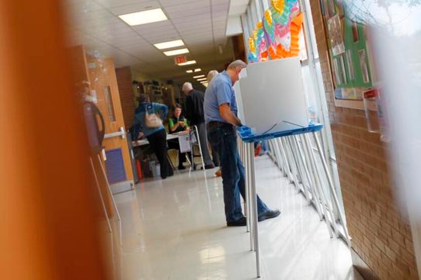A voter helps an election worker find her name at a polling precinct.