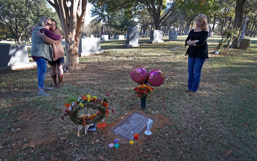 Laura Heinemann, a friend of Taylor Gruwell, hugs Norris at Gruwell's grave at Greenwood...