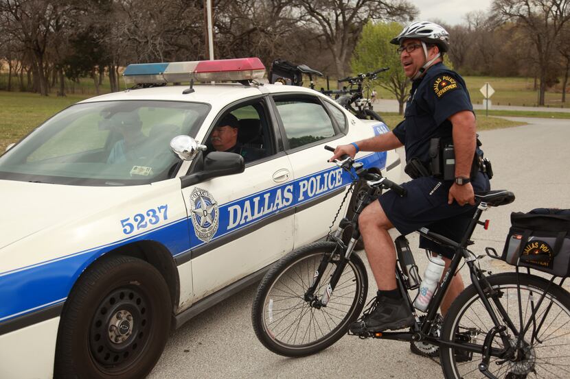 Dallas police officers Juan Amaya (on bike) and Scot Jenkins talked during a patrol  around...