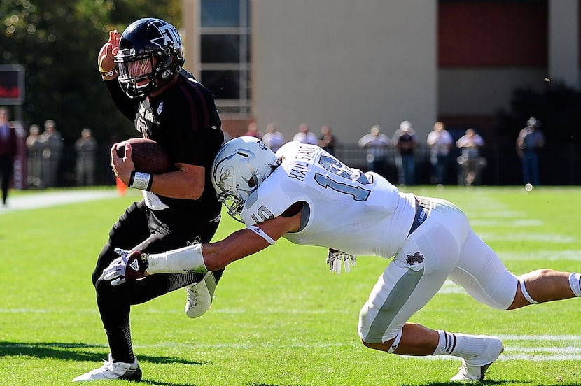 STARKVILLE, MS - NOVEMBER 03:  Johnny Manziel #2 of the Texas A&M Aggies avoids a tackle by...