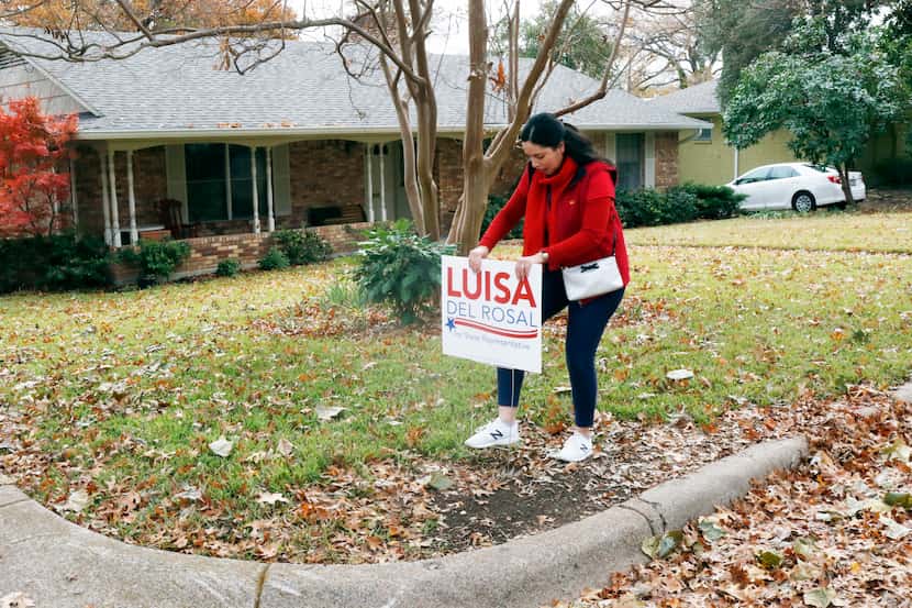 Luisa Del Rosal puts her campaign sign on a supporter's front lawn. She and her campaign...