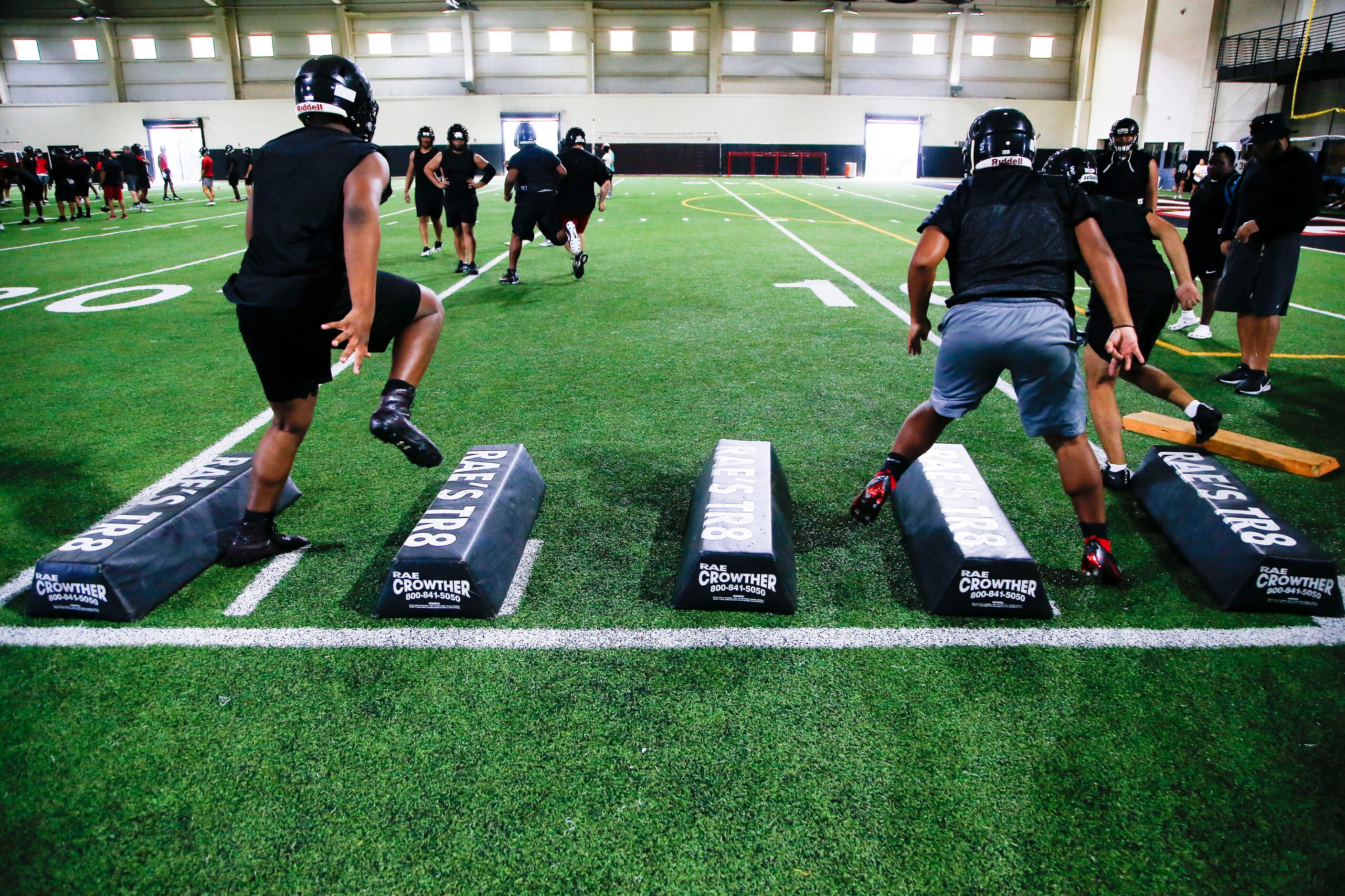 Euless Trinity’s varsity football team runs drills during a practice at Euless Trinity High...