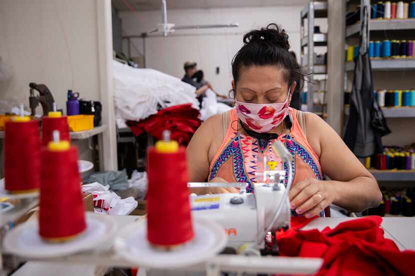Seamstress Brenda Flores makes baby bloomers while wearing a mask at T&Q Cutting Services on...
