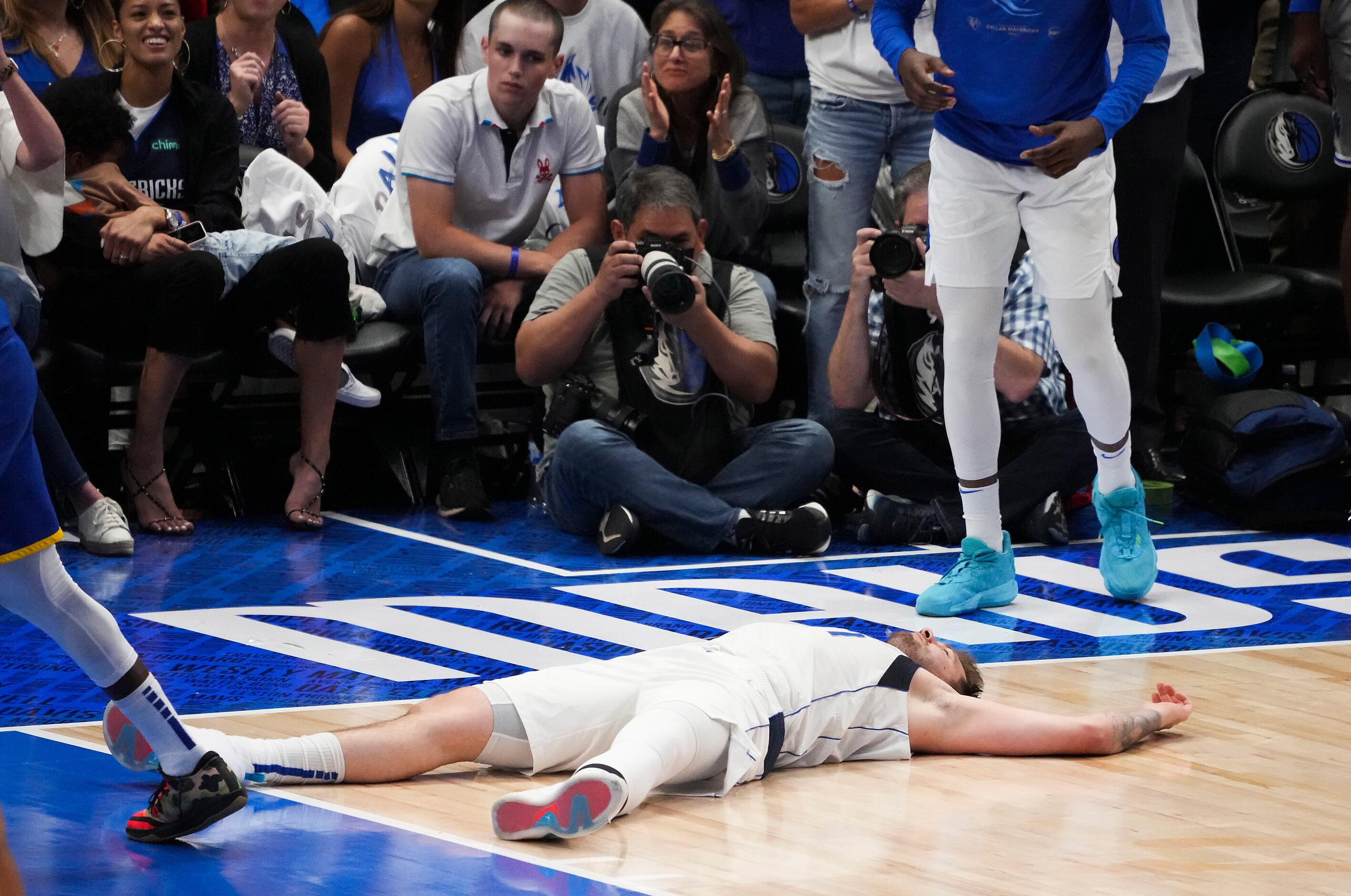 Dallas Mavericks guard Luka Doncic lies on the floor after missing a shot at the end of the...